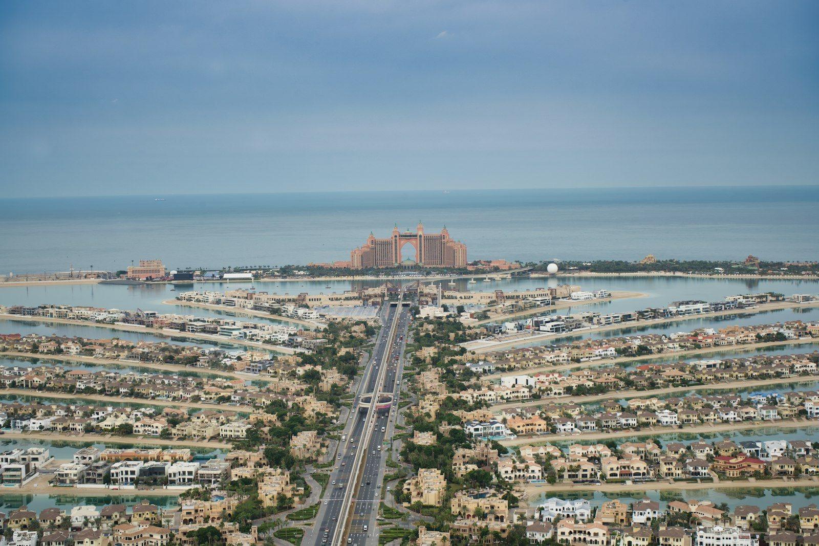 Palm Jumeirah from the air, the fronds packed with beachfront villas either side of the trunk road and the crescent closing the lagoon against the Gulf.